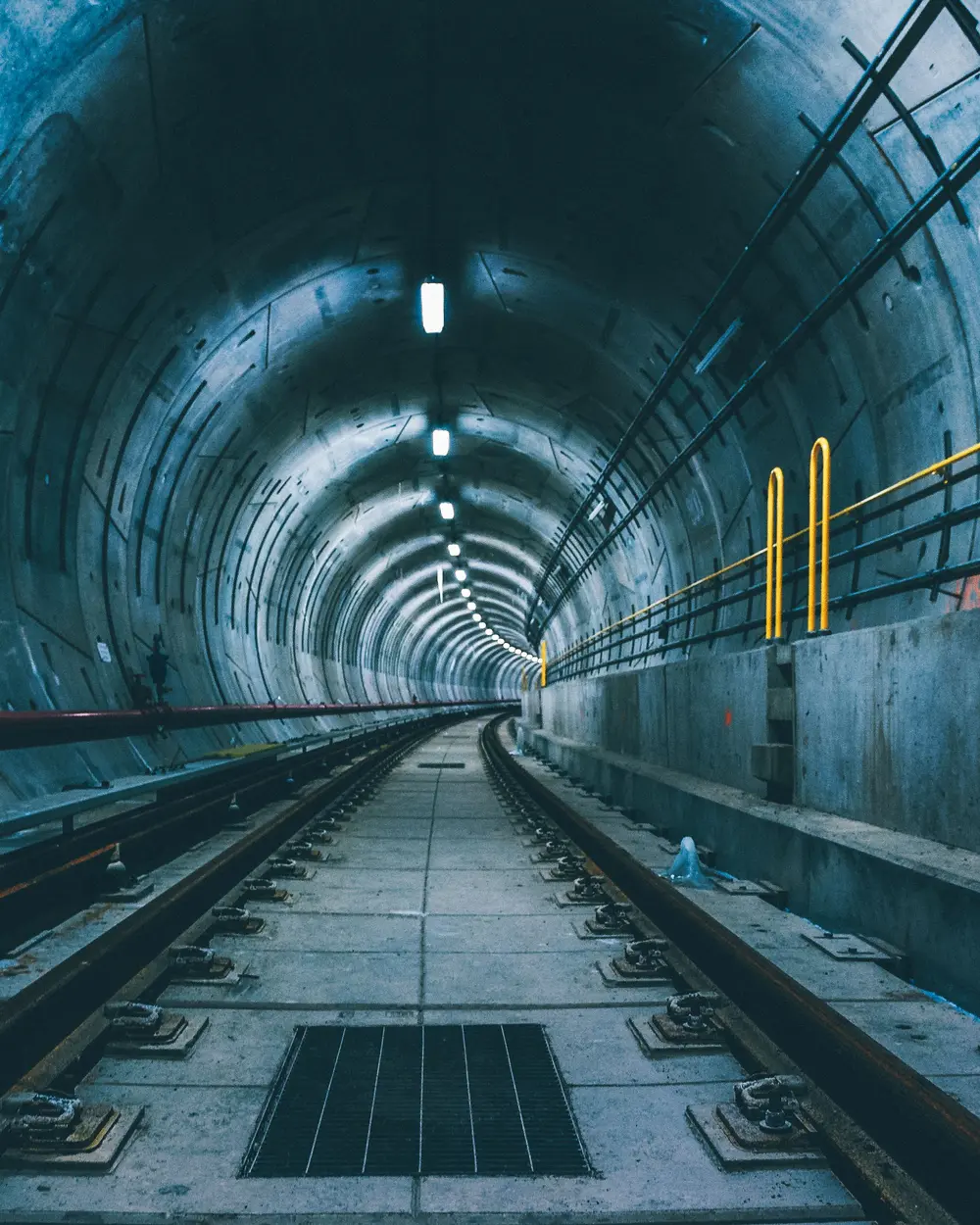 Voie ferrée dans un tunnel ferroviaire éclairé.